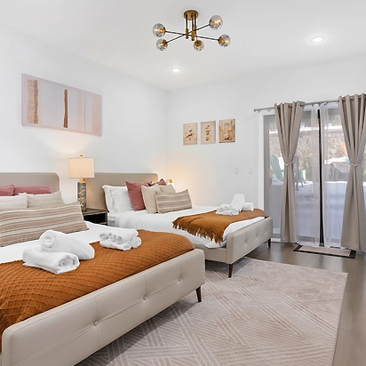 Clean and inviting vacation rental bedroom showing freshly laundered bedding and folded guest towels